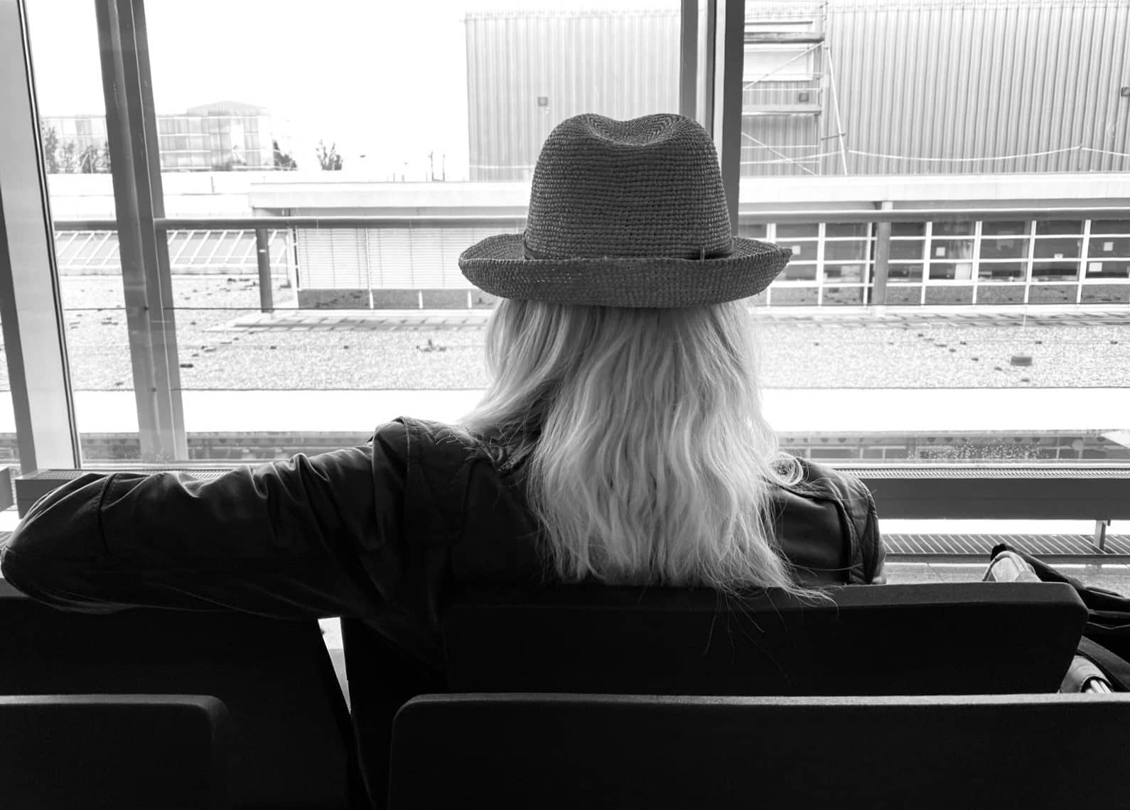 Tina Maria Werner mit Hut, von hinten am Fenster, schwarz-weiß