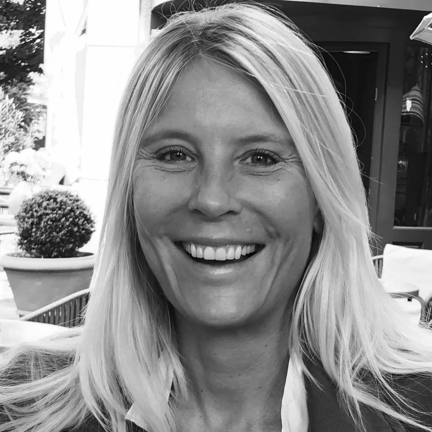 Tina Maria Werner lacht herzlich in die Kamera, schwarz-weiß